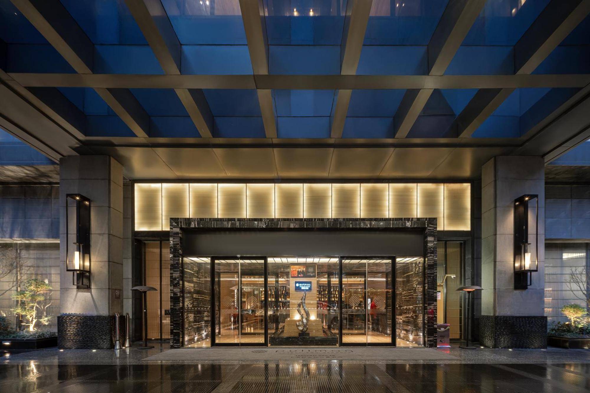 Photographie de la véritable entrée vitrée d’un hôtel avec éclairage chaleureux